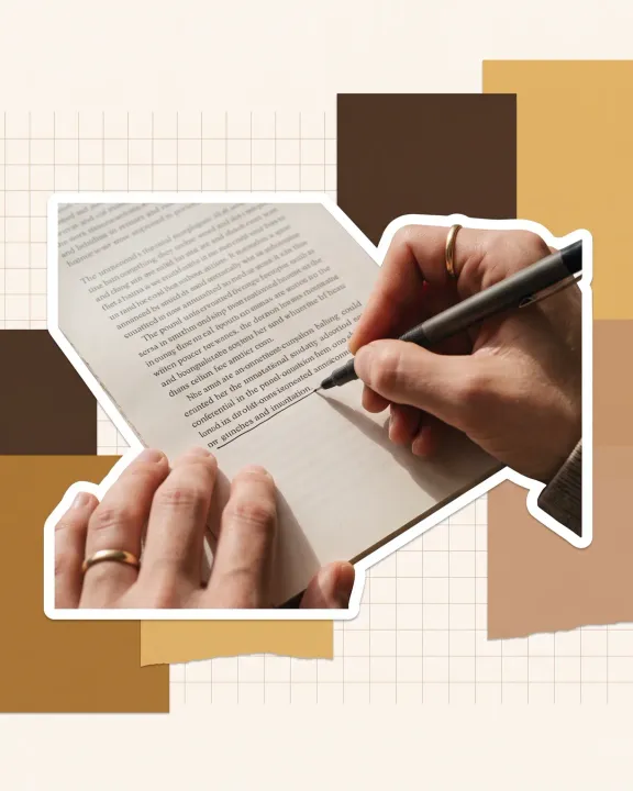 Hands annotating a printed page with a pen, cut out against paper shapes